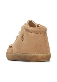 Scarpa alta in camoscio beige con lacci e suola in gomma texturizzata. Presenta un logo impresso di lato e un design a punta arrotondata.