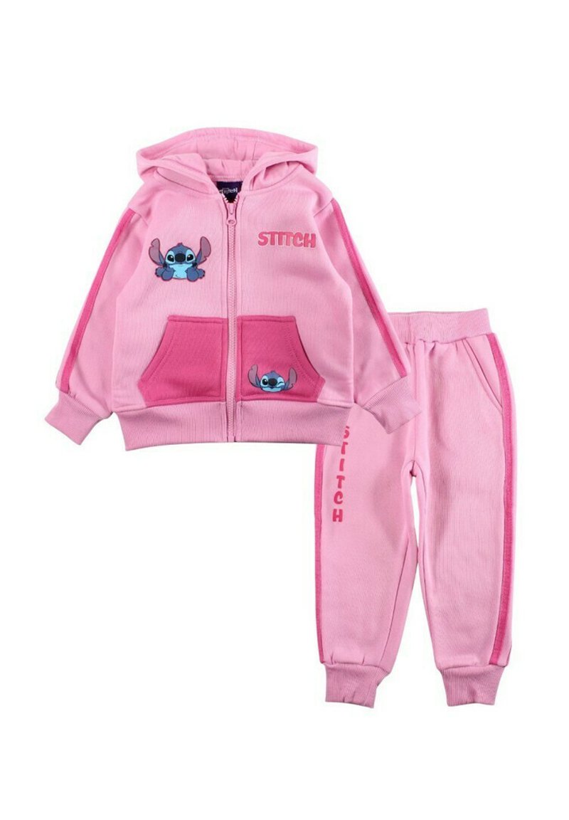 Ensemble de survêtement rose en deux pièces comprenant un sweat à capuche zippé avec des motifs Stitch et des poches, accompagné d'un pantalon assorti avec un détail de marque sur le côté.