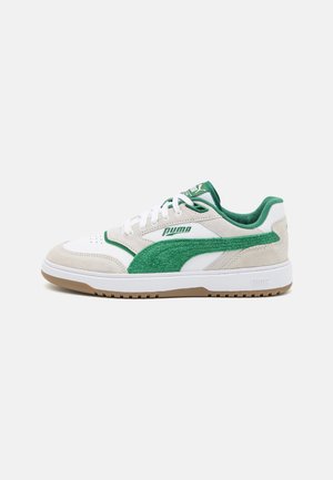 Basket basse Puma blanche et beige avec des détails en daim vert, des lacets blancs et une semelle en gomme, vue de côté extérieur.