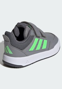 Szary but sportowy z teksturowaną cholewką, zielonymi akcentami, paskiem na rzep i białą podeszwą. Po boku trzy zielone paski.