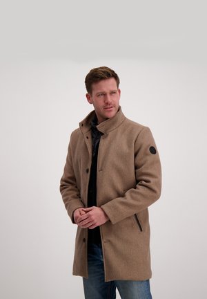 Bruine wollen blend jas met een hoge kraag, voor knopen en zijzakken; gedragen over een zwarte gestructureerde sweater.