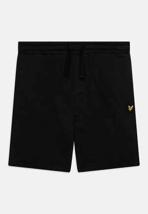 Melnas šortos, kas izgatavoti no mīkstas auduma, ar elastīgu jostu un virvi, kā arī mazu dzeltenu logotipu kreisajā pusē.