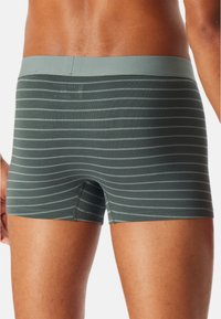 Boxer shorts grigi a strisce realizzati in tessuto morbido, con una vestibilità aderente e un elastico in vita di un grigio chiaro a contrasto.