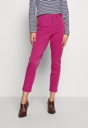 Pantaloni di cotone rosa con vestibilità dritta e orlo a risvolto. Abbinati a una maglietta a righe navy e bianca a maniche lunghe e scarpe con tacco marroni.