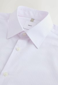 Hellrosa gestreiftes Hemd mit breit gestelltem Kragen, durchgehender Knopfleiste und weißen Knöpfen. Etikett mit der Aufschrift "NEXT". Weiche Stoffstruktur.