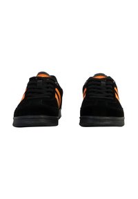 Sneaker in suede nero con dettagli arancioni, caratterizzate da un design con lacci, suole piatte e tre strisce arancioni su ciascun lato.