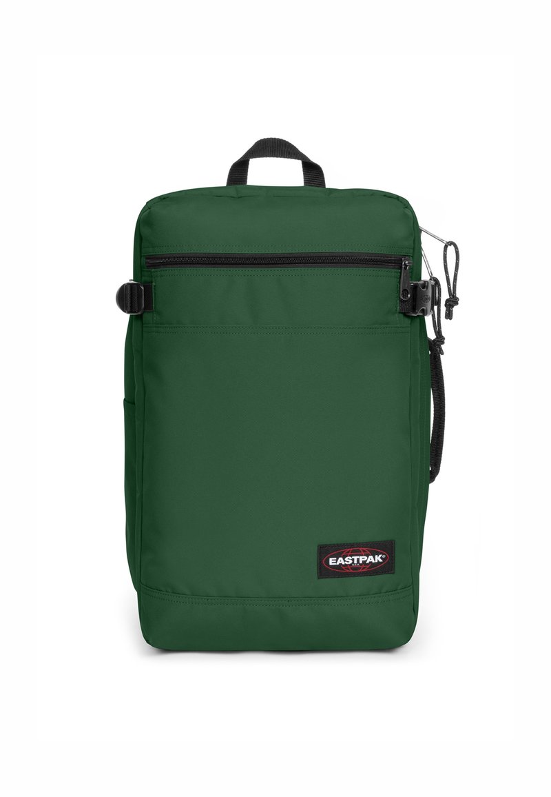 Zaino in nylon verde con forma rettangolare, tasca frontale con zip, manico superiore, tasca laterale e etichetta di marca in basso.