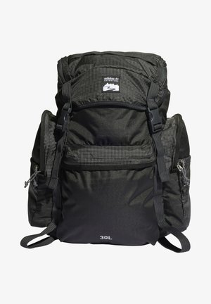 Sac à dos de randonnée noir Adidas Adventure 30L avec plusieurs compartiments zippés et bretelles réglables.