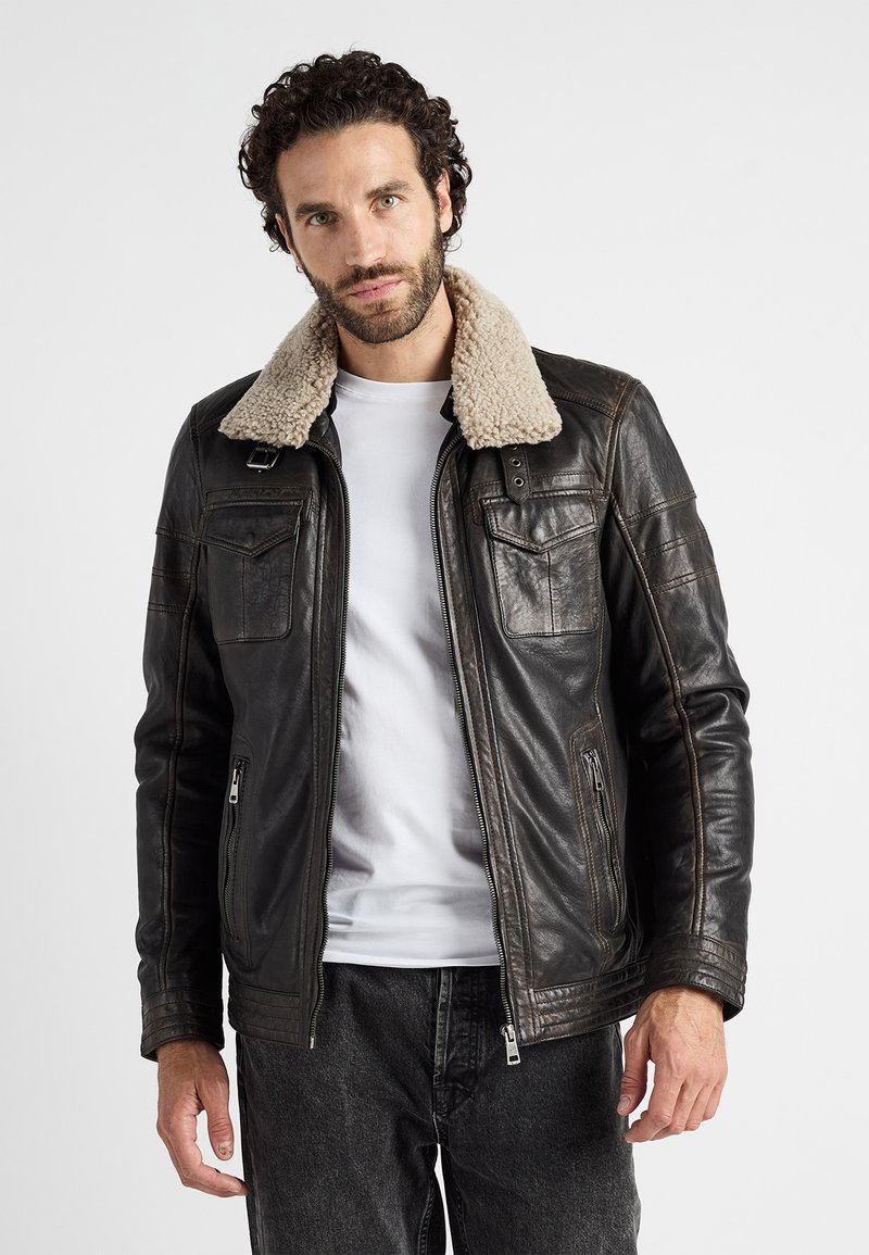 Bruine leren jas met een crème faux shearling kraag, ritssluiting aan de voorkant en twee borstzakken. Heeft een gestructureerde afwerking en een getailleerd ontwerp.