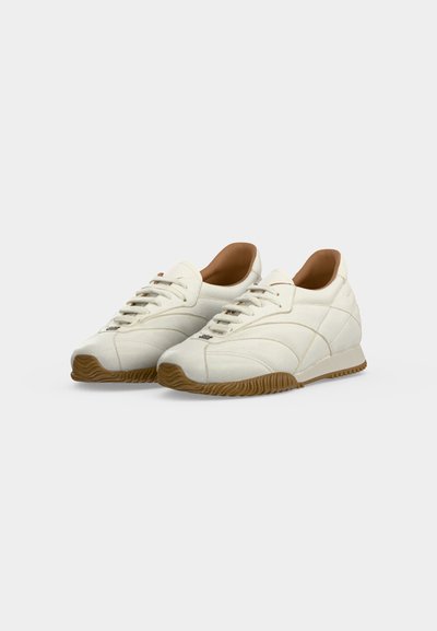 Ζευγάρι λευκά sneakers χαμηλού τύπου με ανοιχτό καφέ σόλες και κορδόνια, που δείχνουν πλαϊνή και εμπρόσθια όψη σε απλό λευκό φόντο.