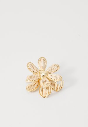 Gold flower hair clip with textured petals and a central bead. Features five petals and a secure clasp design.