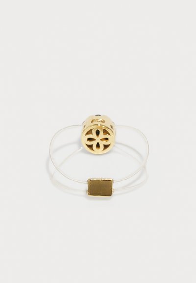 Gold-plated floral design ring with a clear band and a rectangular gold accent, featuring intricate cut-outs and a smooth texture.