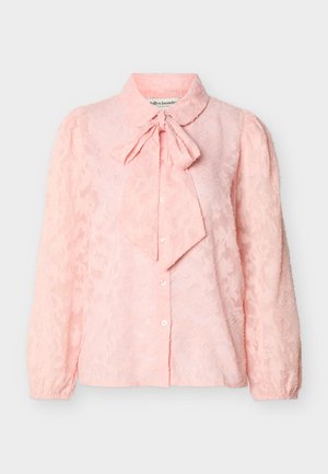 Hellrosa Bluse mit langen Ärmeln, dezentem Blumenmuster, Knopfleiste, aufgepufften Schultern und gebundenem Schleifenkragen.