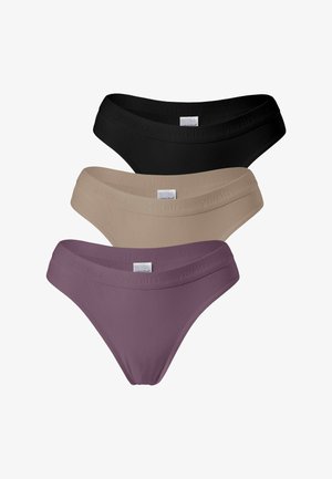 Femme portant un ensemble de sous-vêtements mauve avec une ceinture élastique de marque "yenita" visible, cadrée au niveau du torse et des cuisses, sur un fond uni.