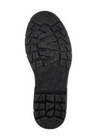 Semelle de chaussure en caoutchouc noir avec un motif de texture et de crampons pour une meilleure adhérence. Présente un profil plat et une taille marquée 37. Durable et conçue pour offrir une bonne traction.