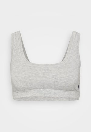 Bralette cinza, suave, de algodão com alças largas e decote arredondado. Apresenta uma faixa ajustada na parte inferior e um pequeno detalhe do logótipo na lateral.