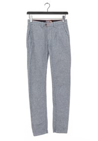 Pantaloni grigi intrecciati con una trama liscia, davanti piatto, tasche laterali e design slim fit, appesi a un gancio nero.