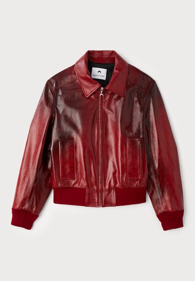 Červená kožená bombardérka s lesklým povrchem, žebrovanými manžetami a spodním lemem a dvěma předními kapsami. Obsahuje špičatý límec a zipové zapínání.