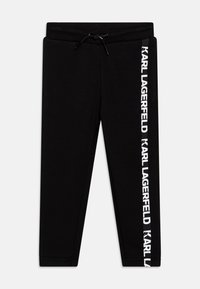 Svarta sweatpants i bomull med elastisk midja och dragsko, samt en vit logoprint längs sidan.