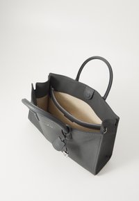 Bolso tote de cuero gris, con un exterior texturizado, asas dobles, un bolsillo con cremallera y un forro interior beige.