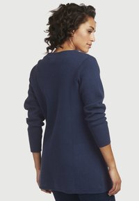 Navyblaues Langarm-Pullover mit strukturiertem Strick, Rundhalsausschnitt und lässiger Passform, mit umgeschlagenen Bündchen und einem Saum, der bis zur Hüfte fällt.