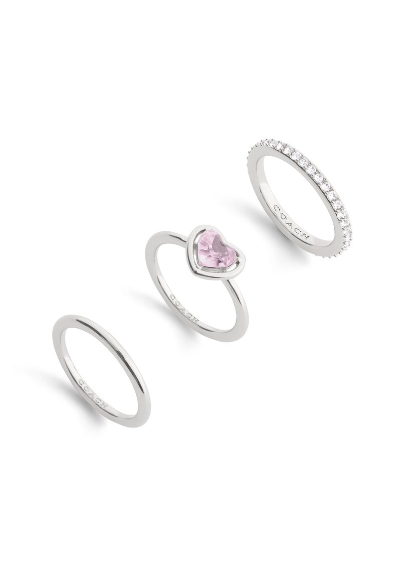 Three silver rings: one with a heart-shaped pink gemstone, one plain band, one adorned with small clear stones along the band.