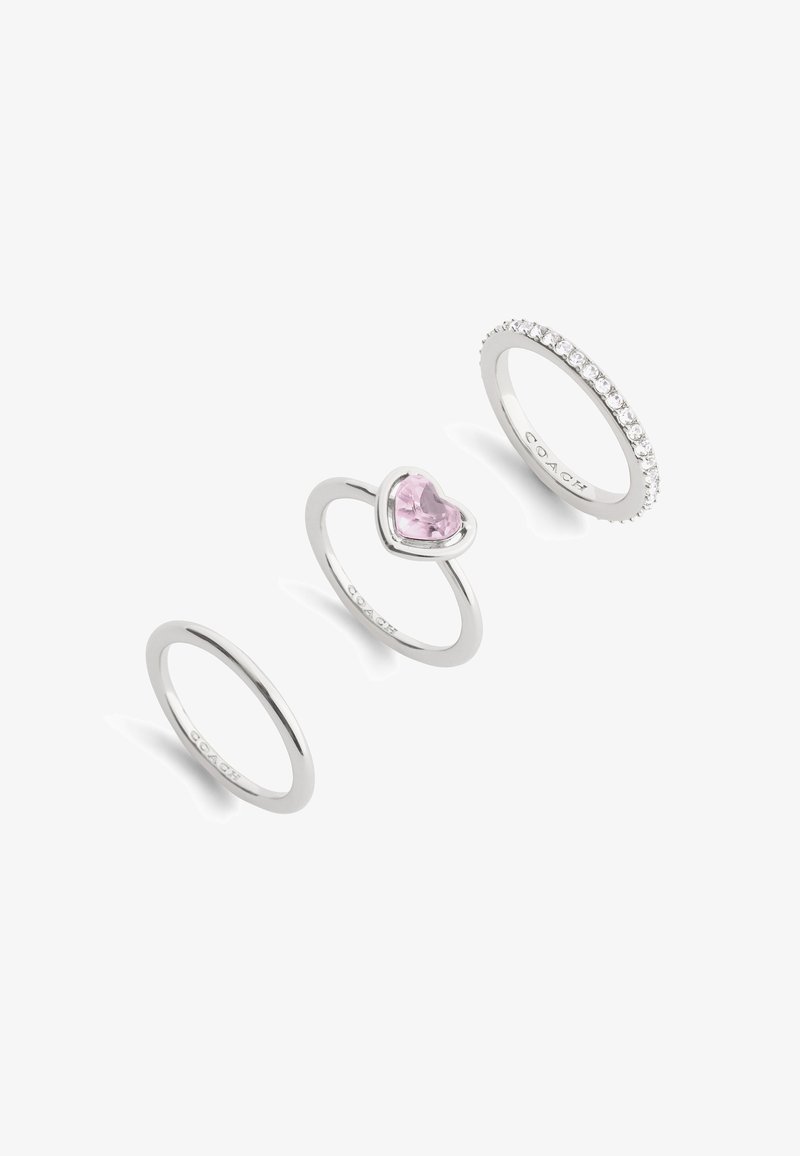 Three silver rings: one with a heart-shaped pink gemstone, one plain band, one adorned with small clear stones along the band.