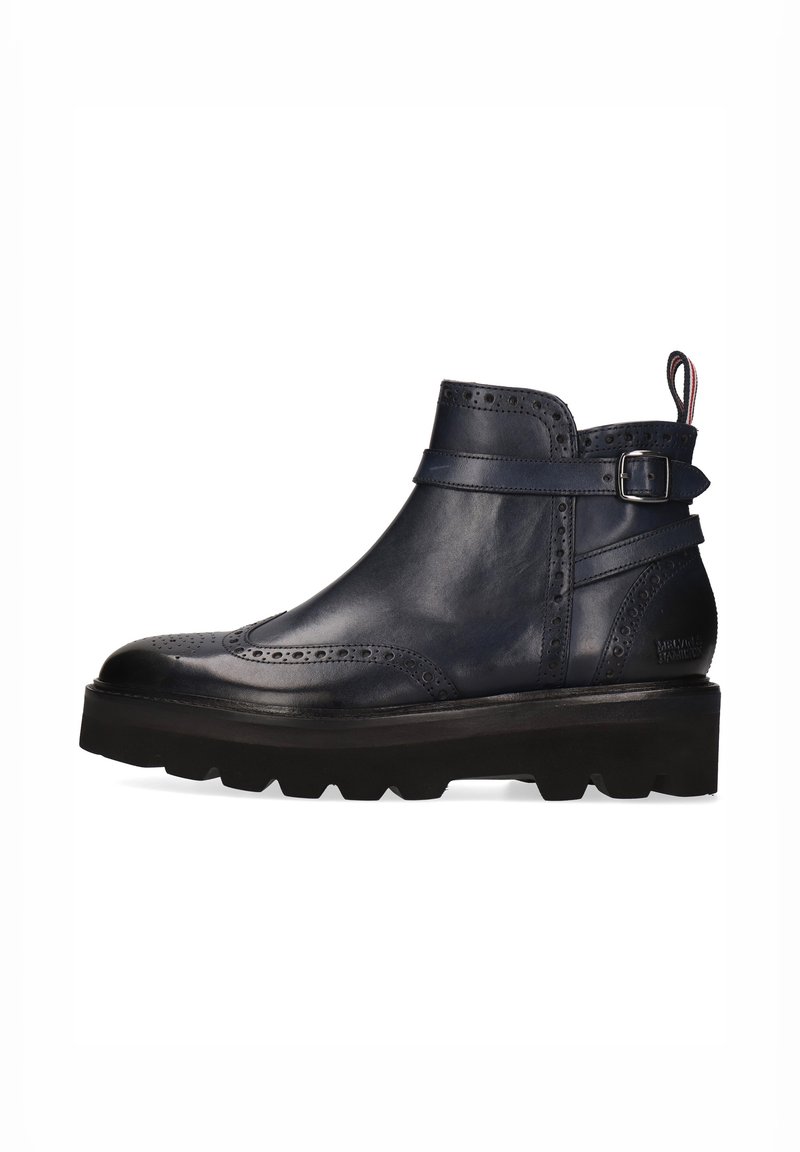 Botas de cuero azul marino hasta el tobillo con detalles decorativos de brogue, una correa con hebilla y una suela negra gruesa. Textura suave y diseño elegante.