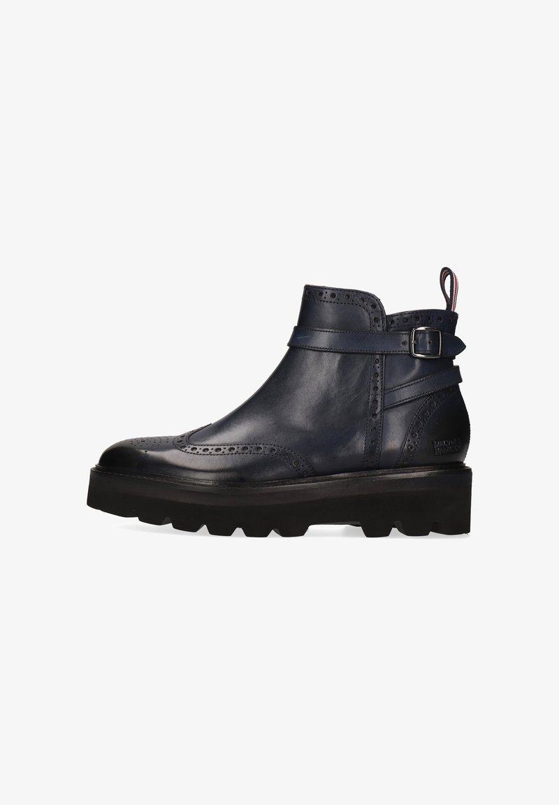Botas de cuero azul marino hasta el tobillo con detalles decorativos de brogue, una correa con hebilla y una suela negra gruesa. Textura suave y diseño elegante.
