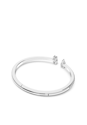 Brazalete de plata con un diseño liso y redondeado. Presenta una delicada fila de piedras transparentes a lo largo de un lado. Estilo elegante y minimalista.