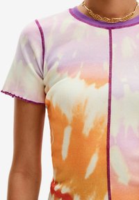 Tričko s krátkým rukávem ve stylu tie-dye v pastelových barvách fialové, oranžové a žluté. Žebrovaná textura s kontrastním růžovým prošíváním podél švů.