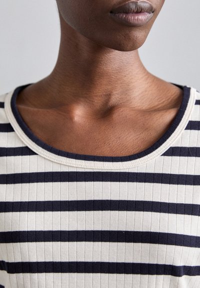 Ribbed striped top featuring navy blue and cream horizontal stripes, with a wide rounded neckline and smooth texture.