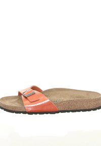 Orange patent leather sandal with a cork footbed, adjustable strap, and metallic buckle detail. Black rubber sole. Casual, open-toe design.