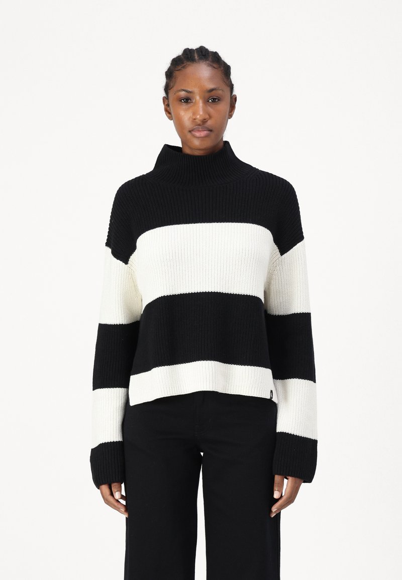 Maglione lavorato a maglia a righe bianche e nere con colletto alto, texture a coste e maniche lunghe. Progettato con una vestibilità rilassata e un'orlo corto.