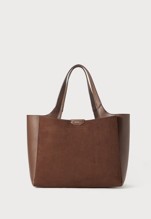 Brown tote bag with leather and suede texture, featuring a structured design, dual handles, and a logo plaque at the top.