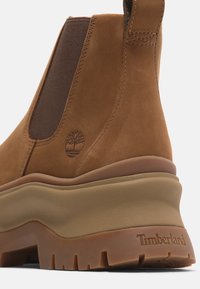 Bruna mockaskinn Chelsea-stövlar med elastiska sidopaneler, tjock tansula i gummi och präglad Timberland-logga. Texturerad mellansula och detaljering på sulan.