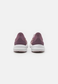 Baskets de sport violettes avec un dessus texturé, une semelle intermédiaire blanche et des accents roses. Talon profilé pour le soutien et le confort.
