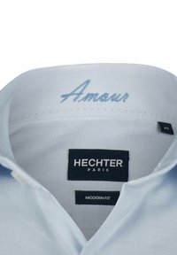 Lichtblauwe katoenen overhemd met een moderne pasvorm, voorzien van een patroon, geborduurd "Amour" en merktekens: Hechter Paris, maat 40.