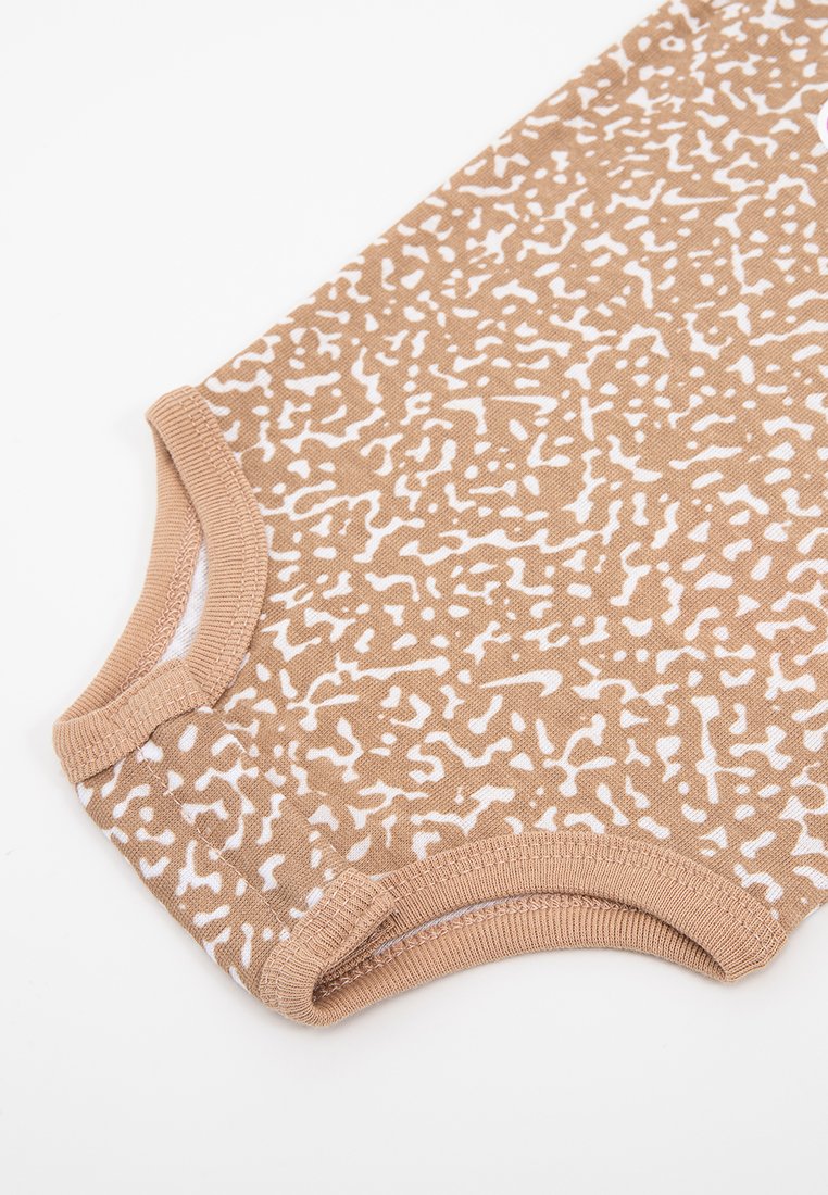 Chemise à manches courtes beige avec un motif abstrait blanc, col rond côtelé et texture de tissu douce.