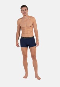 Námořnické modré boxerky s kontrastním černým pasem, na kterém je logo. Hladký materiál a přiléhavý střih, vhodné pro každodenní nošení.