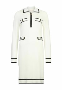 Abito di maglia bianco con colletto, chiusura lampo frontale e dettagli neri. Presenta due tasche decorative con loghi e polsini e orlo a costine.