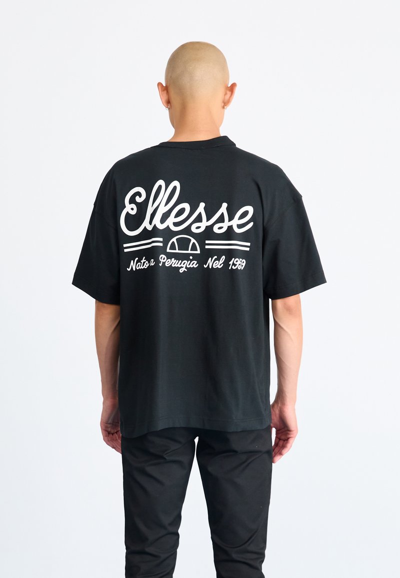 Juoda marškinėliai su laisvu kirpimu, ant nugaros esantis baltas "Ellesse" logotipas ir tekstas "Nato a Perugia Nel 1959". 100% medvilnė, trumpomis rankovėmis.