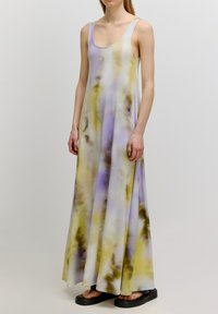 Maxi-jurk in een tie-dye patroon met lavendel, geel en bruine tinten. Gemaakt van zachte, vloeiende stof met brede bandjes en een losse pasvorm.