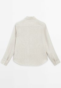 Jasno beżowa koszula z długim rękawem z delikatnym wzorem w paski, z guziczkami przy mankietach, kołnierzykiem w kształcie punktu i zaokrąglonym tyłem.