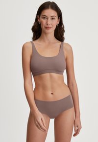 Bruine stoffen draadloze bh met brede banden en een gladde textuur, gecombineerd met bijpassend bikini-ondergoed in een vergelijkbare tint.