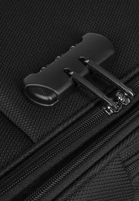 Primo piano di una borsa nera in tessuto con una doppia cerniera dal finish opaco e una superficie testurizzata, che mette in evidenza materiali resistenti e dettagli di cucitura.
