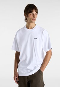T-shirt en coton blanc avec un col rond, des manches courtes et un petit logo Vans brodé sur la poitrine gauche. Coupe décontractée.