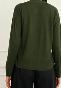 Cardigan lavorato a maglia di un verde scuro, con una vestibilità rilassata, orlo e polsini a coste. Presenta una texture tenue e un design minimalista. Vista posteriore mostrata.