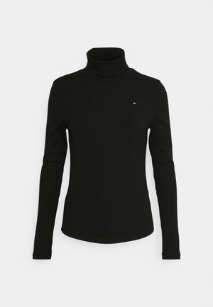 Schwarzer Rollkragenpullover aus geripptem Stoff. Verfügt über lange Ärmel und ein kleines Logo mit roten und weißen Akzenten auf der Brust.