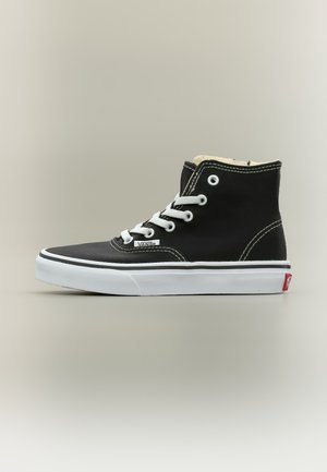 Μαύρο ψηλό αθλητικό παπούτσι Vans με λευκά κορδόνια, λευκή λαστιχένια σόλα και ορατές ραφές σε απλό φωτεινό φόντο.